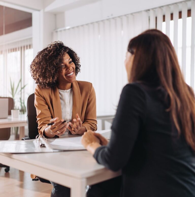 An estate planning professional site with her client at a table, discussing her clients will.